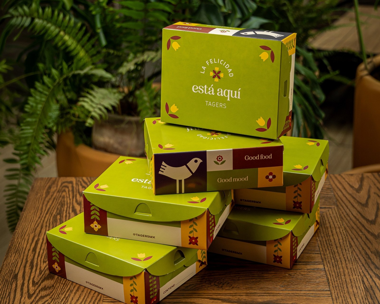 Cajas box infantiles de Tagers apiladas sobre una mesa de madera, con el mensaje La felicidad está aquí