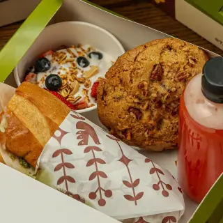 Box Lunch de Tagers abierto: baguette, galleta, jugo y fruta con yogur