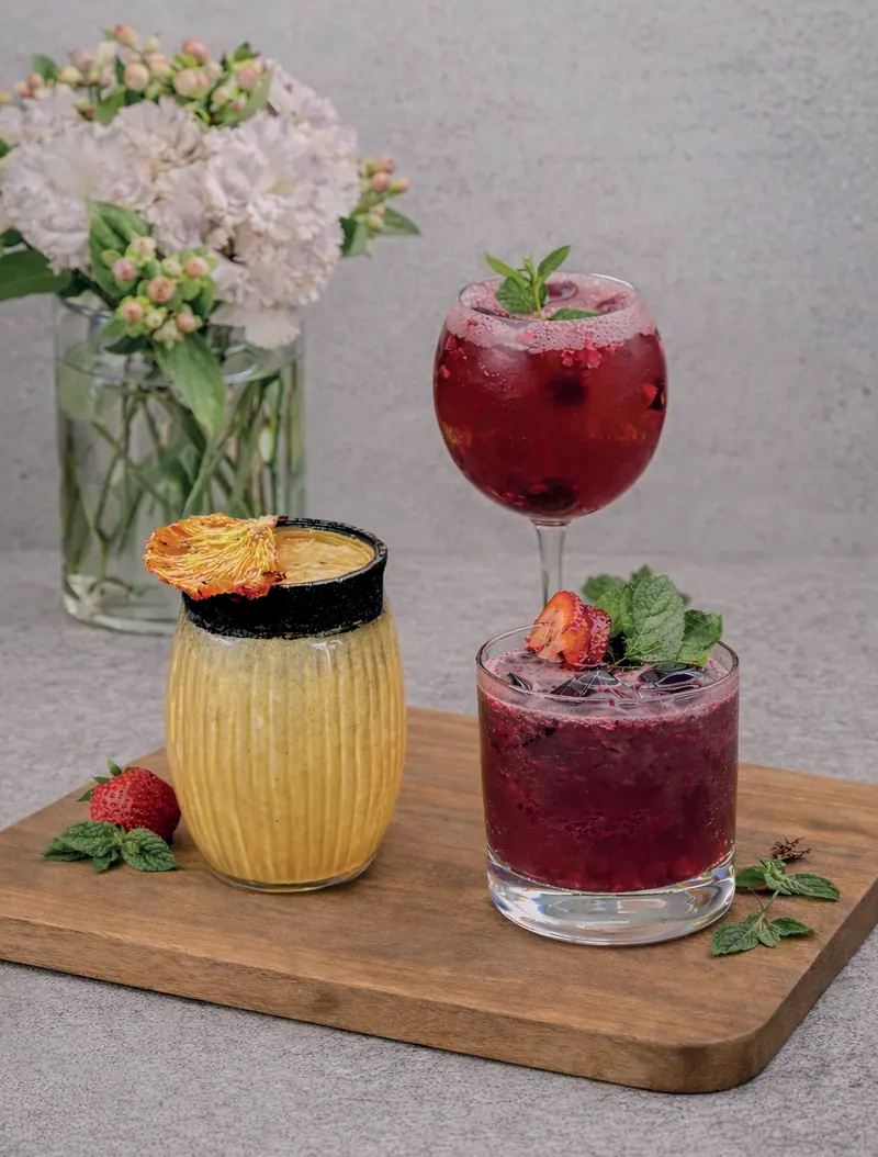 Charred pineapple mezcalina, gin pintadito and red berry mezcal on a wooden board