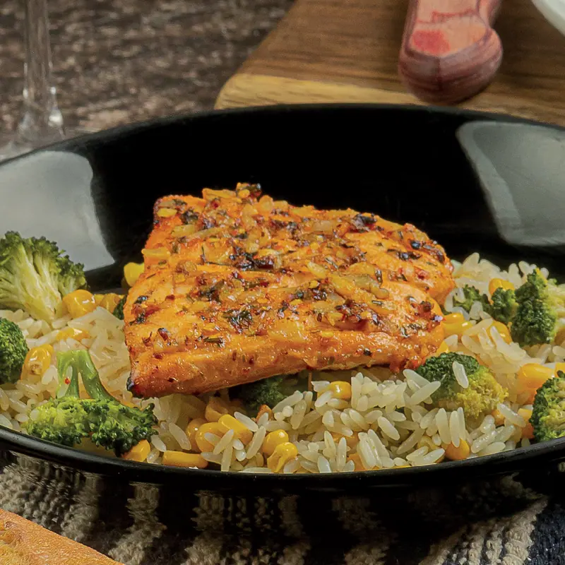 Salmon in a garlic and lemon crust over rice with broccoli and corn