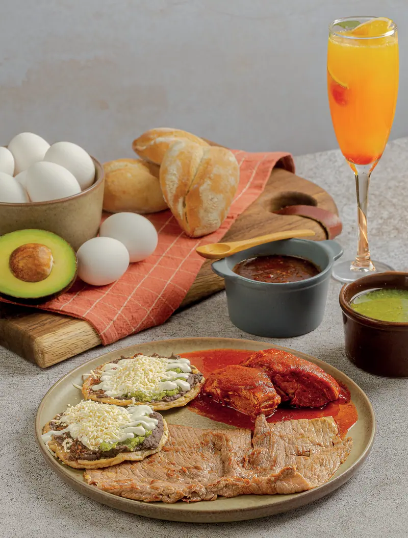 Combined breakfast: picaditas, pork in adobo and grilled cecina, with an Aperol mimosa