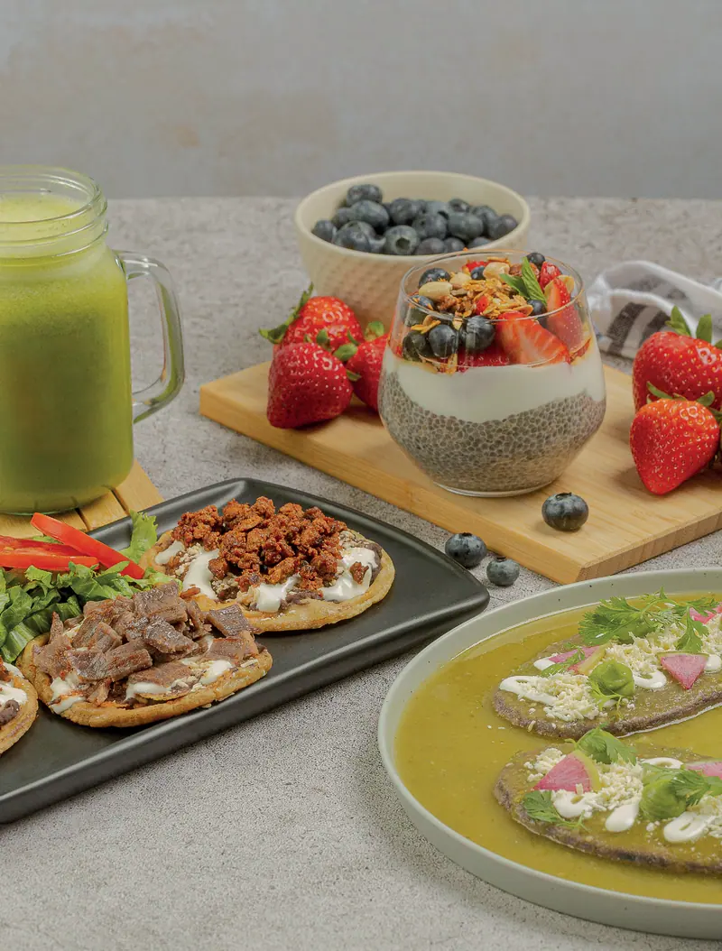 Chia pudding with berries, house picaditas and tlacoyos drowned in green salsa