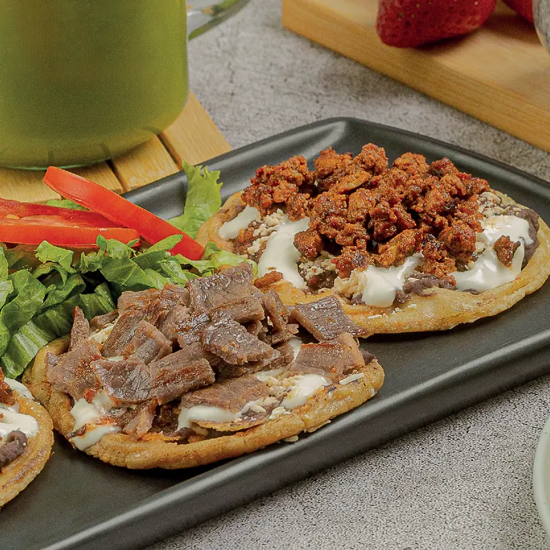 House picaditas with beans, cream, cotija cheese and their topping