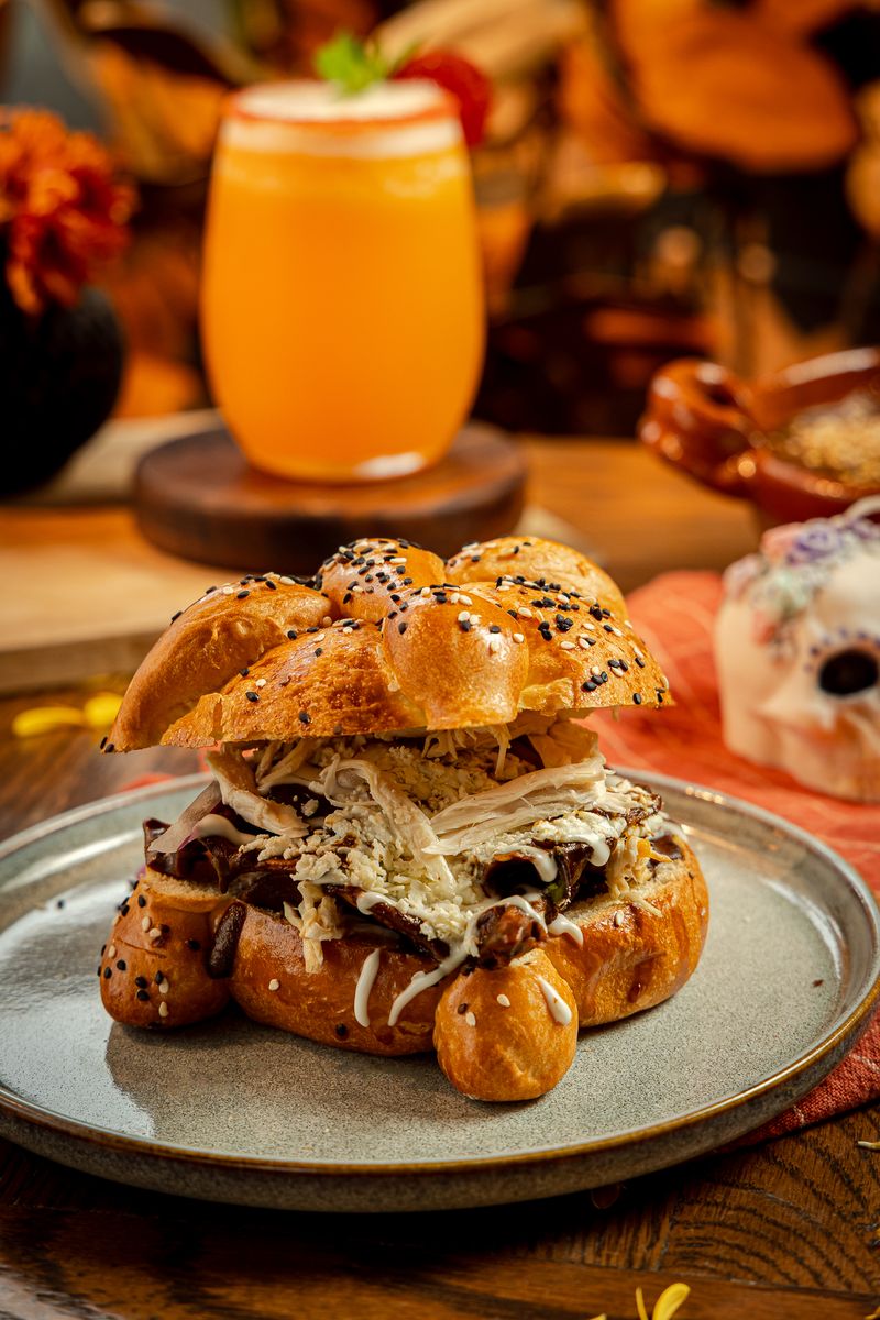 Catrín de mole: pan de muerto de ajonjolí relleno de chilaquiles en mole