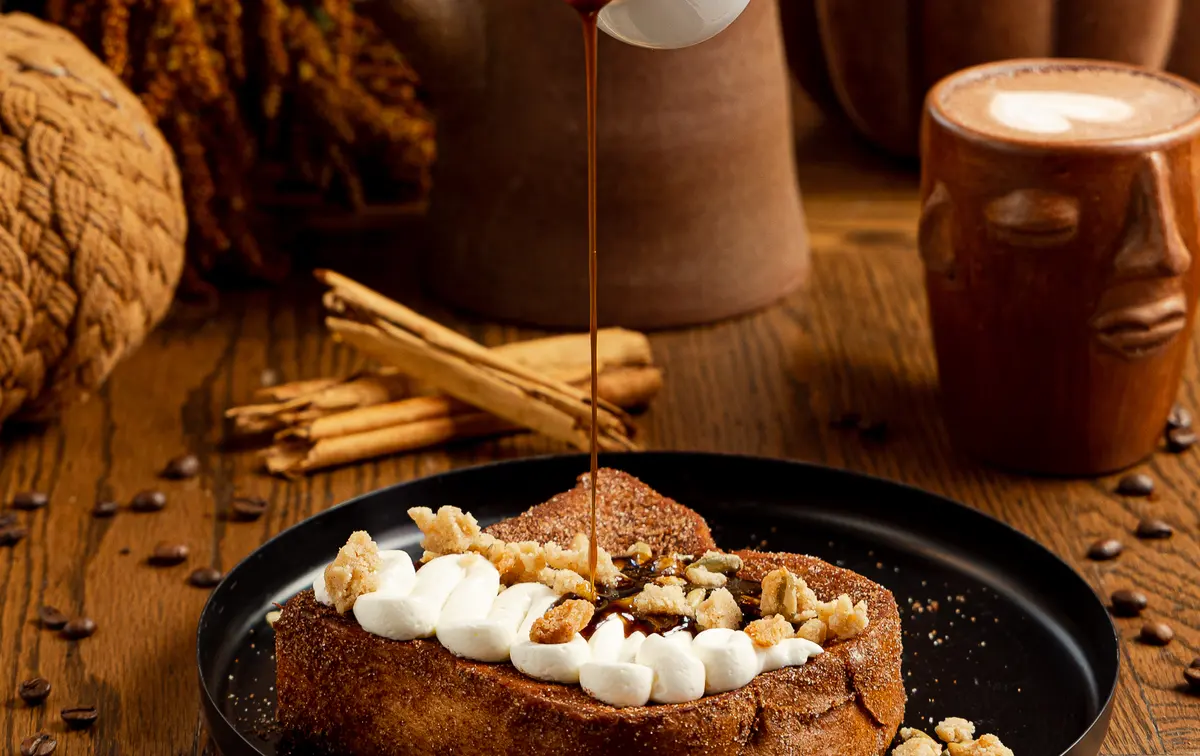 French toast de café de olla con crema de ricota mientras le sirven miel de piloncillo