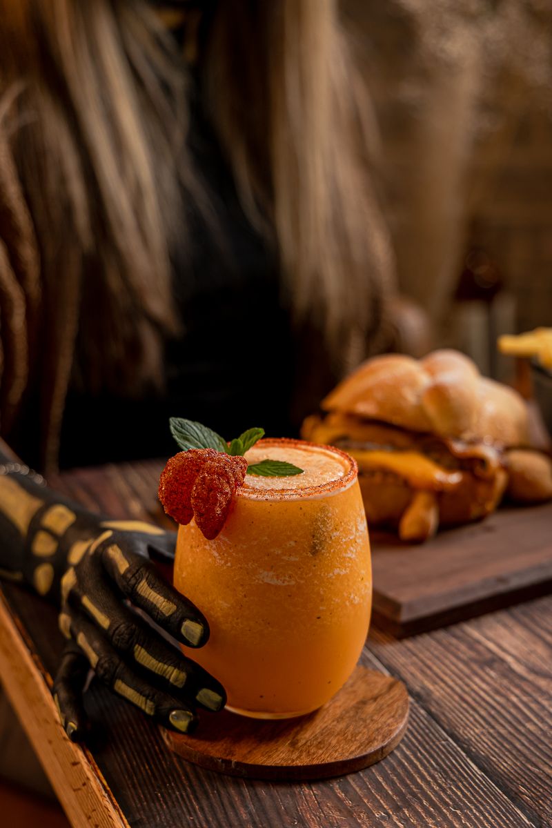 Mandarina cooler servido por una mano con guante de esqueleto