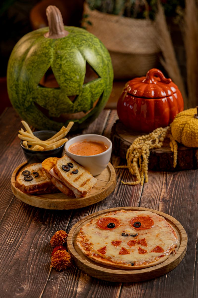 Spooky grilled cheese con papas y salsa de jitomate; al frente, la Monster pizza con carita