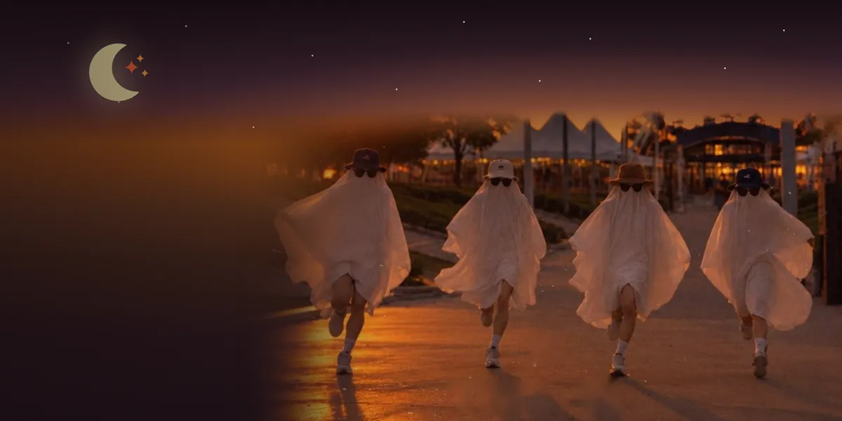 Cuatro corredores disfrazados de fantasma corren al atardecer en Sendela, bajo la luna