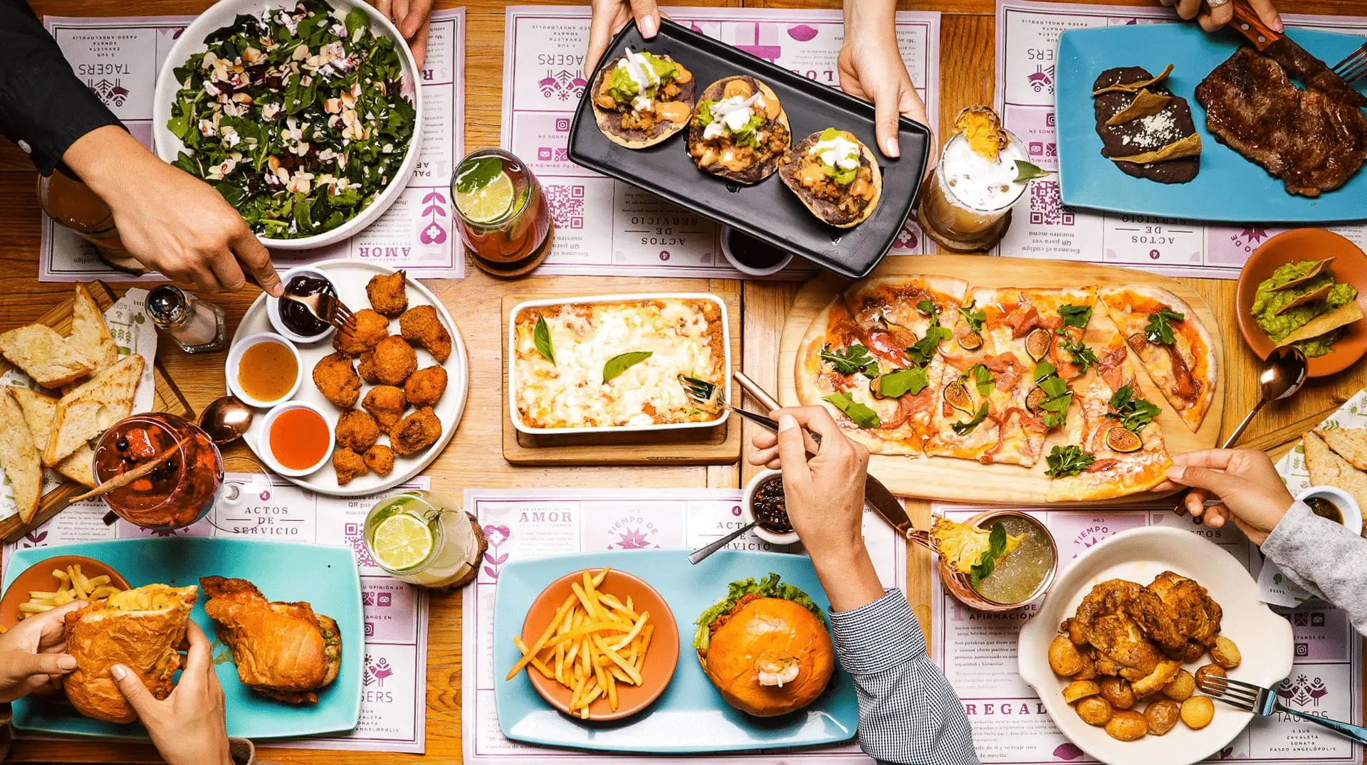 Mesa compartida con platillos, pan recién horneado y bebidas de Tagers