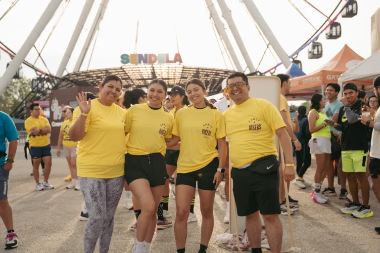 Participantes del Social Run de Yellow Day de Tagers sonriendo frente al letrero de Sendela, bajo la Estrella de Puebla