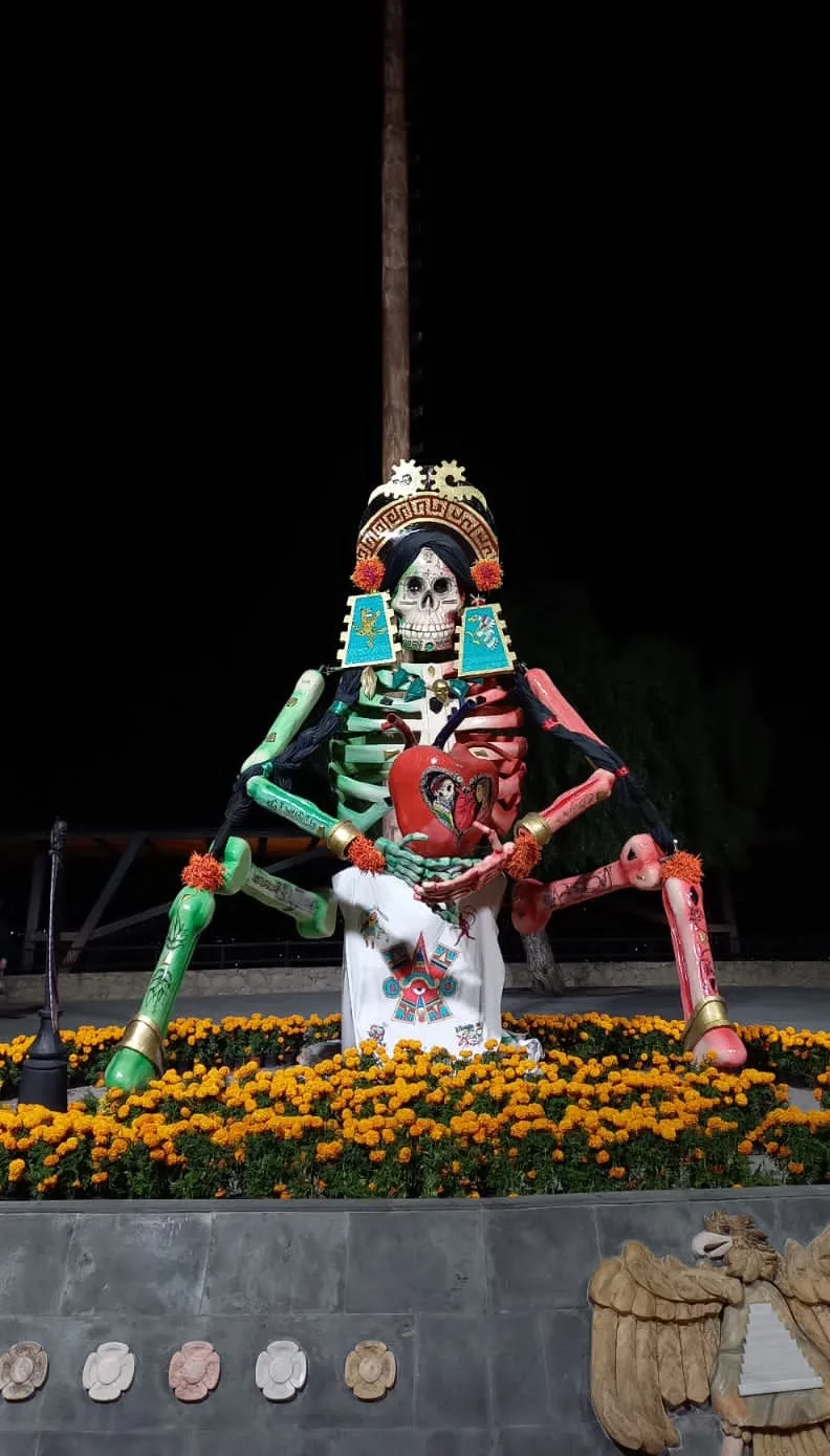 Catrina monumental de cartonería de colores, con flores de cempasúchil, en el Valle de Catrinas de Atlixco en 2024