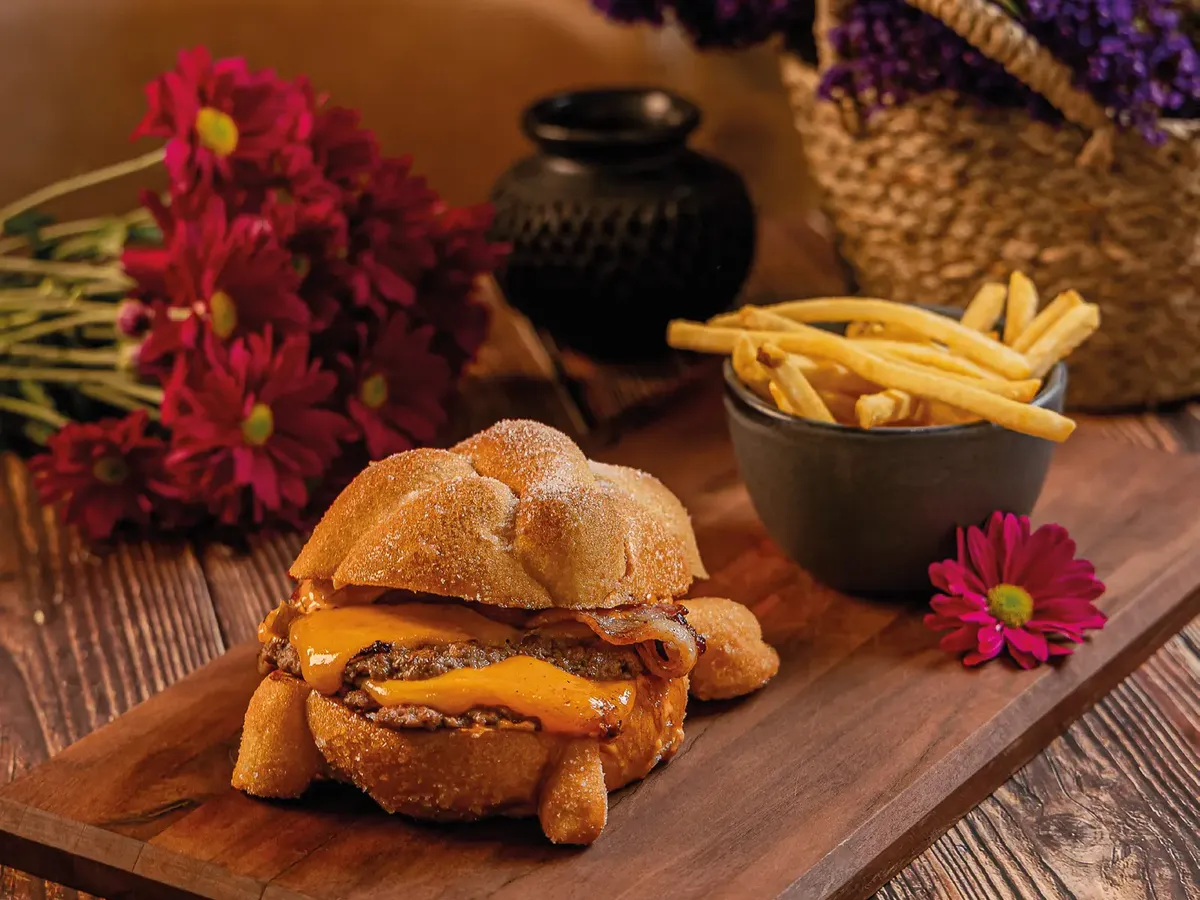 Catrina smash burger de Tagers: dos carnes smash con queso cheddar y tocino dentro de un pan de muerto azucarado, con papas crispy