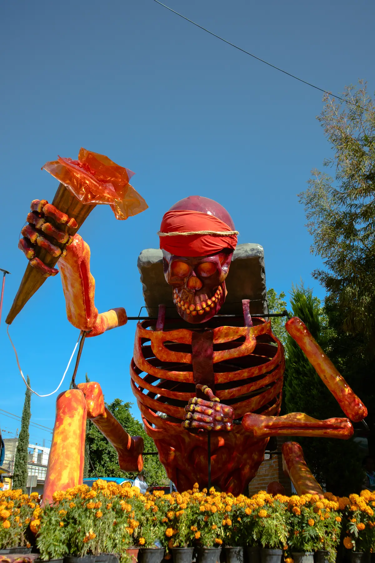 Catrina monumental de cartonería de El Pípila, con una antorcha en alto y flores de cempasúchil a sus pies, en el Valle de Catrinas de Atlixco en 2024