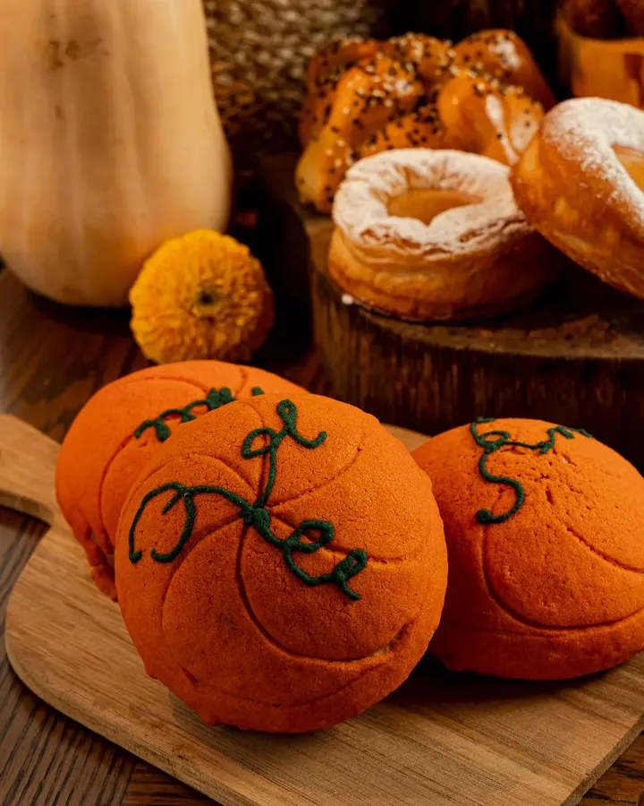 Conchas anaranjadas en forma de calabaza, rellenas de dulce de calabaza, sobre una tabla de madera