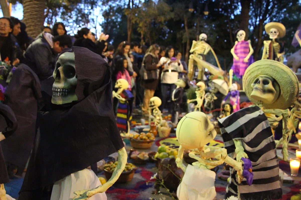 Ofrenda con calaveras, catrines de papel maché y velas en una celebración de Día de Muertos en Coyoacán