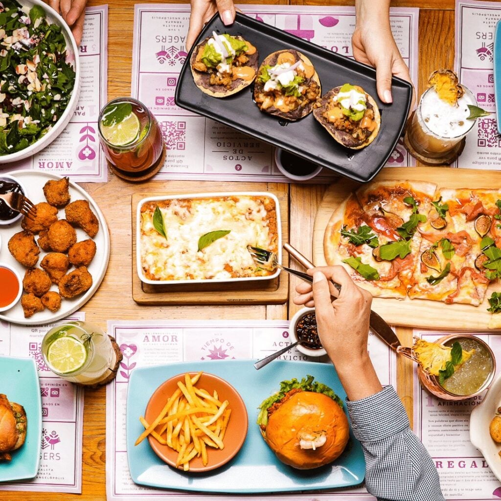 Mesa compartida con platillos, pan recién horneado y bebidas de Tagers