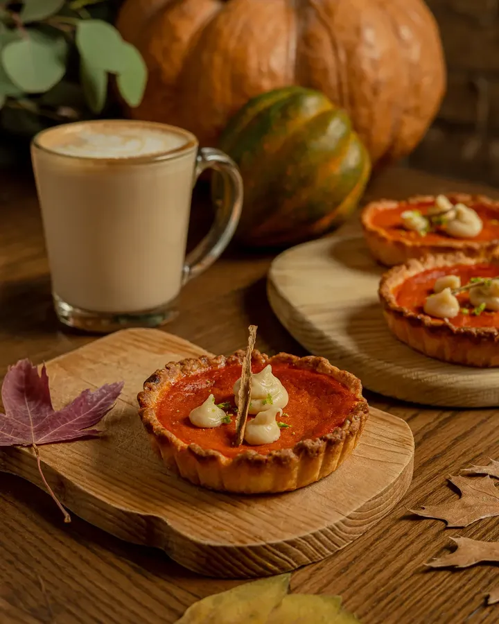 Pay de calabaza individual de Tagers junto a una taza de café y calabazas