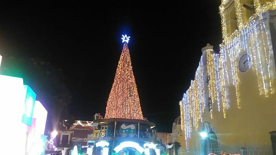 Árbol de Navidad gigante de luces doradas frente a la fachada iluminada de una iglesia en Atlixco, enero de 2020