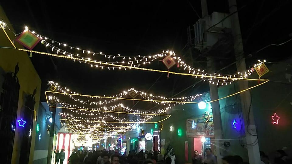 Hileras de focos cálidos cruzando una calle de Atlixco llena de gente, enero de 2020