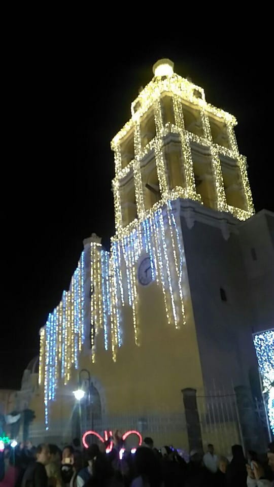 Torre de una iglesia de Atlixco cubierta de luces blancas y doradas en la Villa Iluminada, enero de 2020