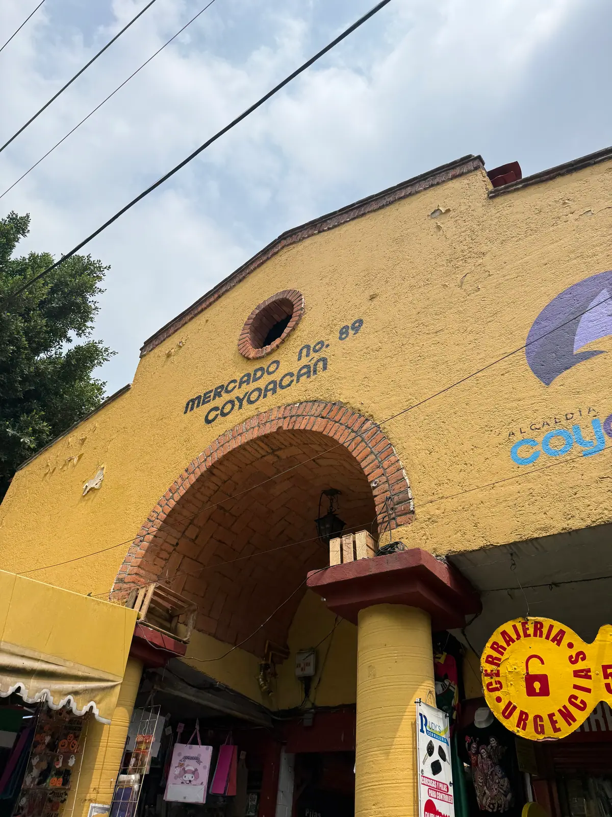 La fachada amarilla del Mercado de Coyoacán con su arco de entrada y el letrero «Mercado No. 89 Coyoacán»
