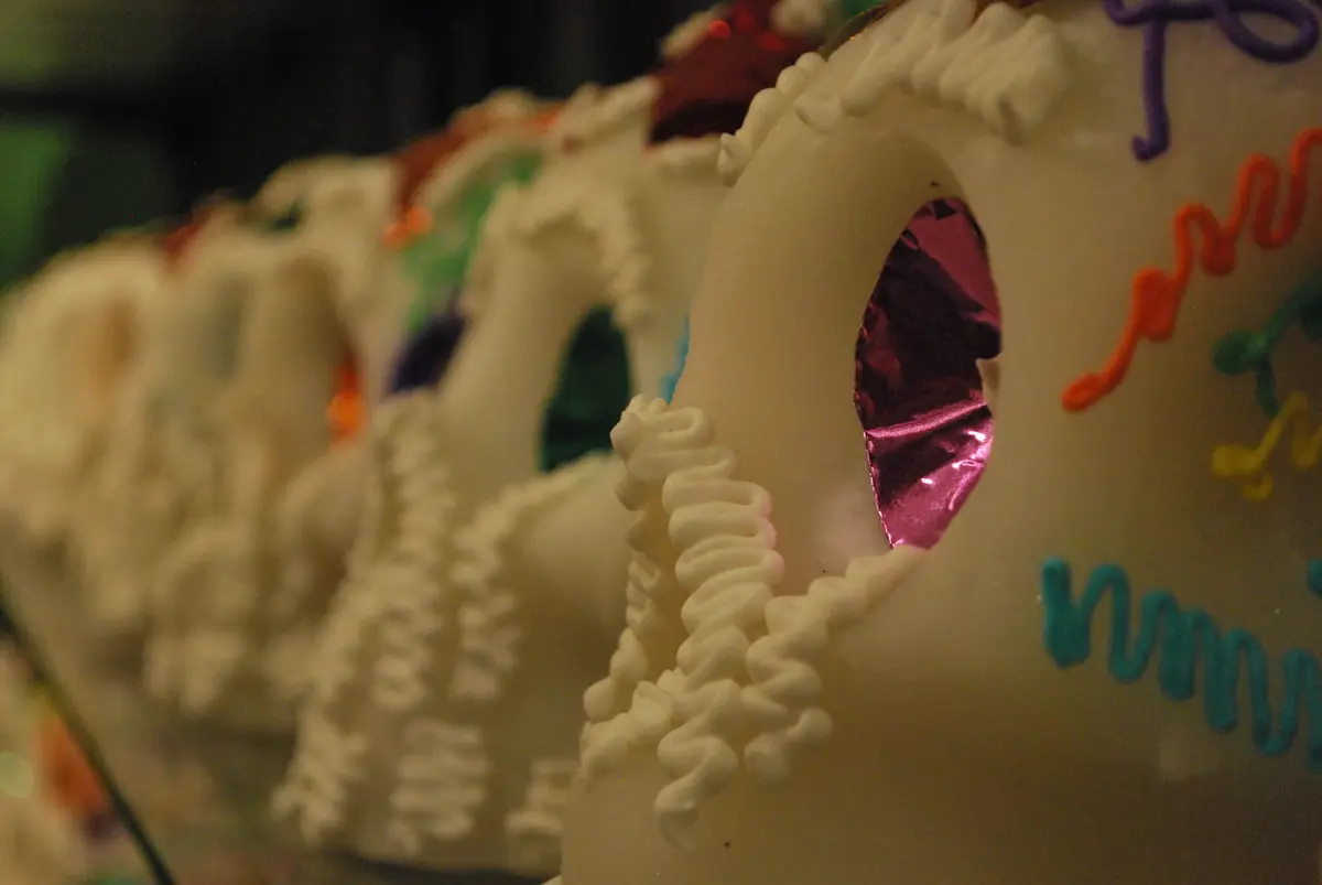 Una fila de calaveritas de azúcar blancas decoradas con betún de colores