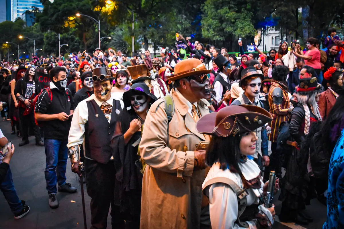Decenas de participantes con sombreros, trajes de época y maquillaje de catrina avanzan por la calle en la Mega Procesión de Catrinas