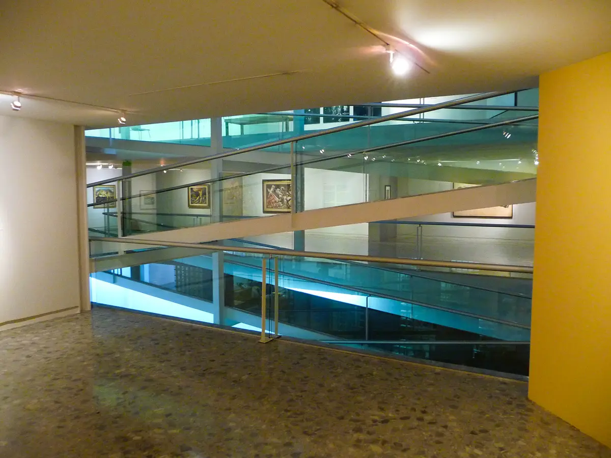 Las rampas y salas del interior del Museo de Arte Carrillo Gil, con un muro amarillo y vidrio