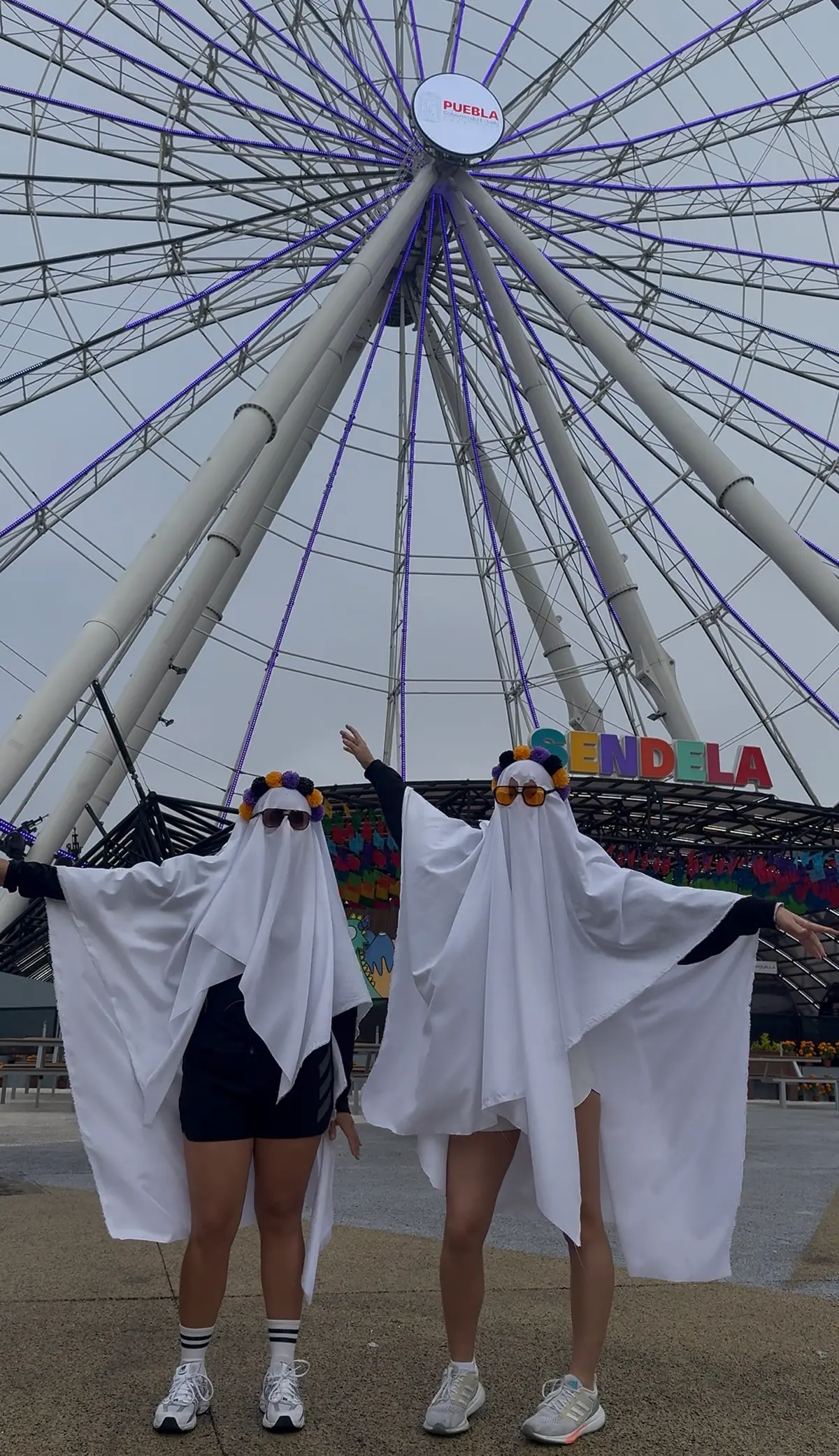 Dos corredoras disfrazadas de fantasma frente a la Estrella de Puebla
