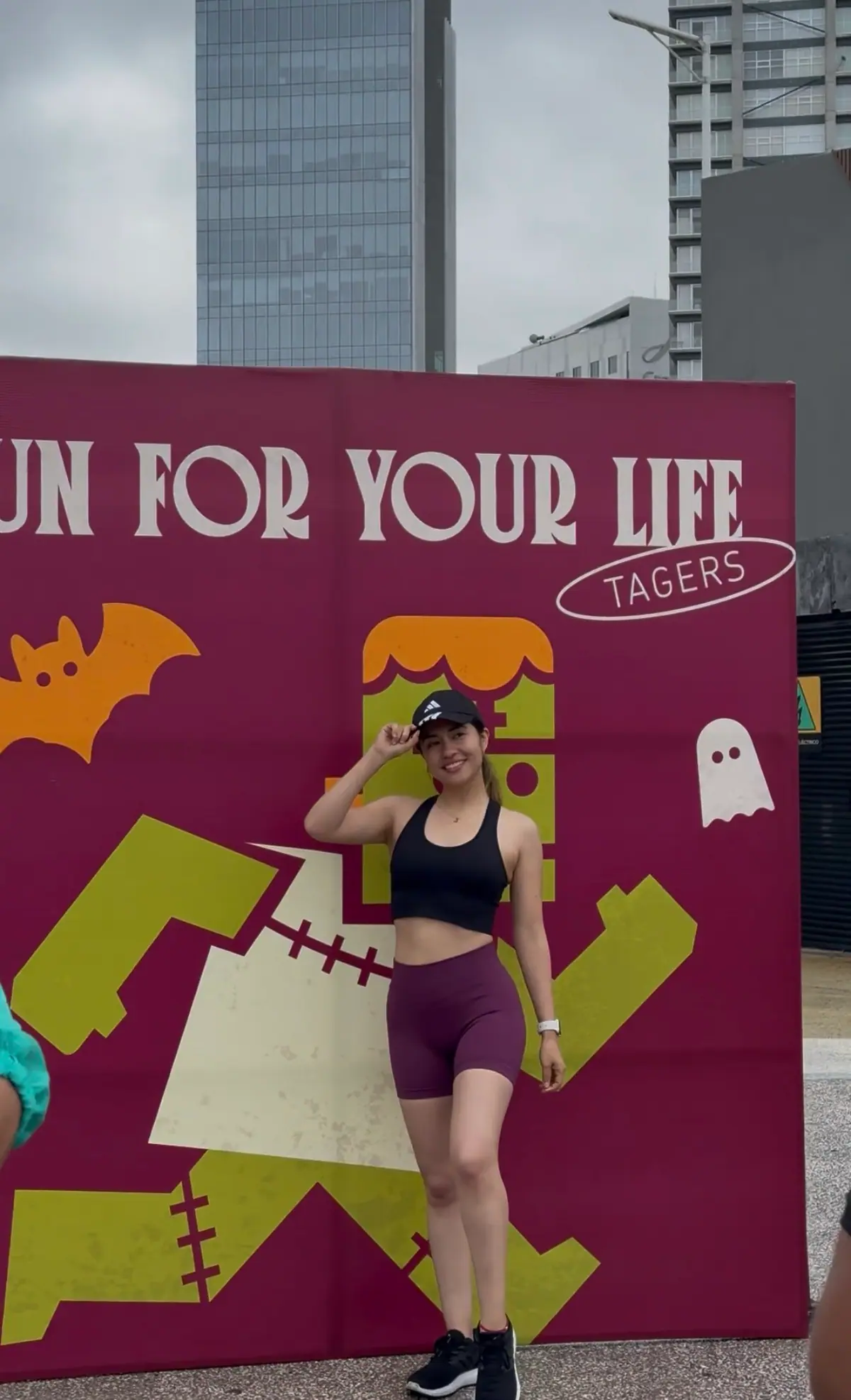 Corredora saluda frente al muro Run for your life de la Spooky Run