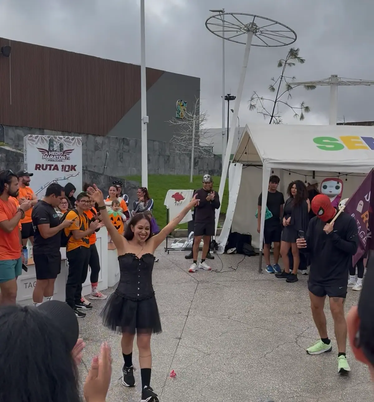 Participante con vestido negro de tul desfila en el concurso de disfraces