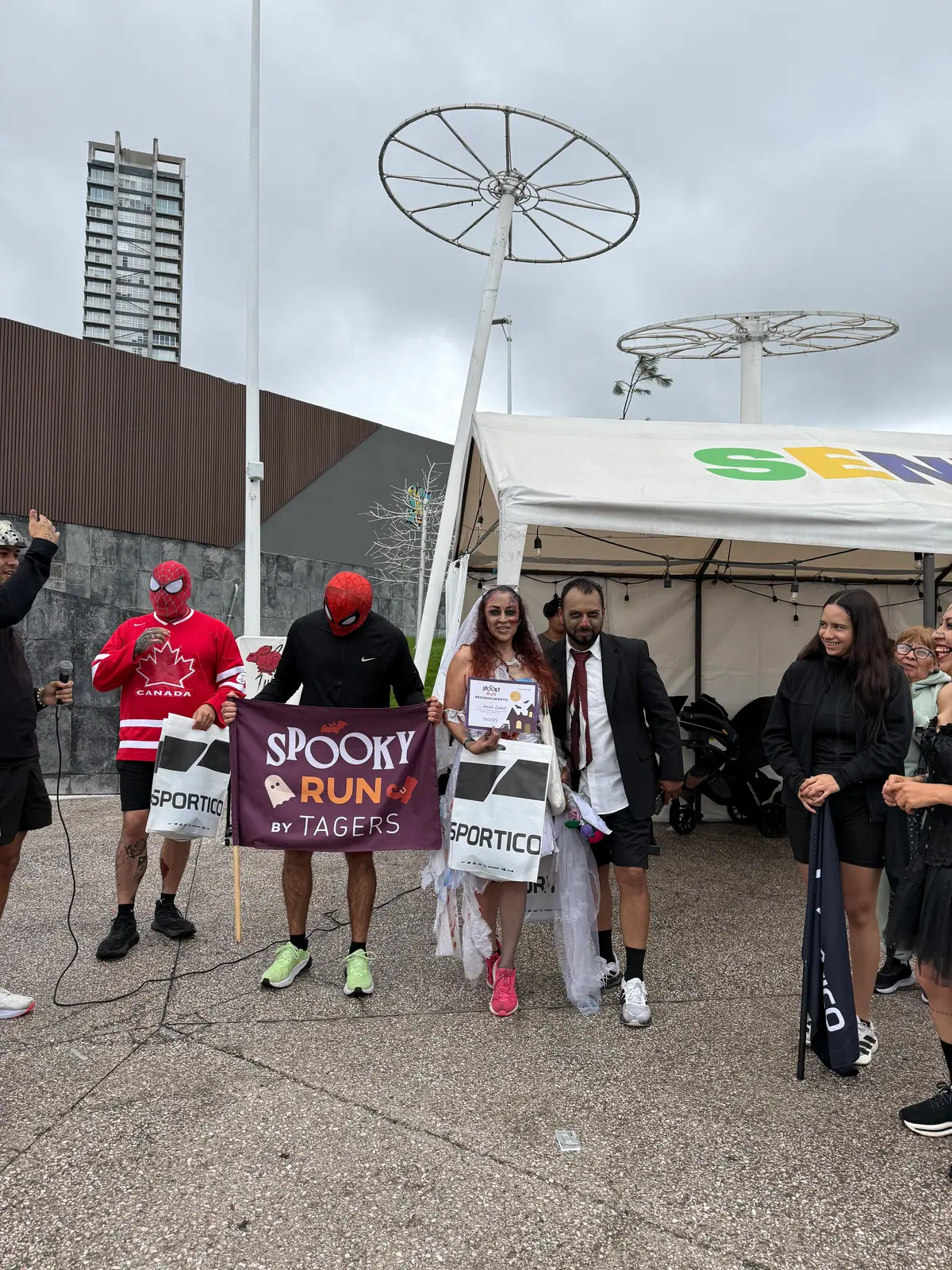 Participantes disfrazados con sus reconocimientos y la bandera de la Spooky Run by Tagers