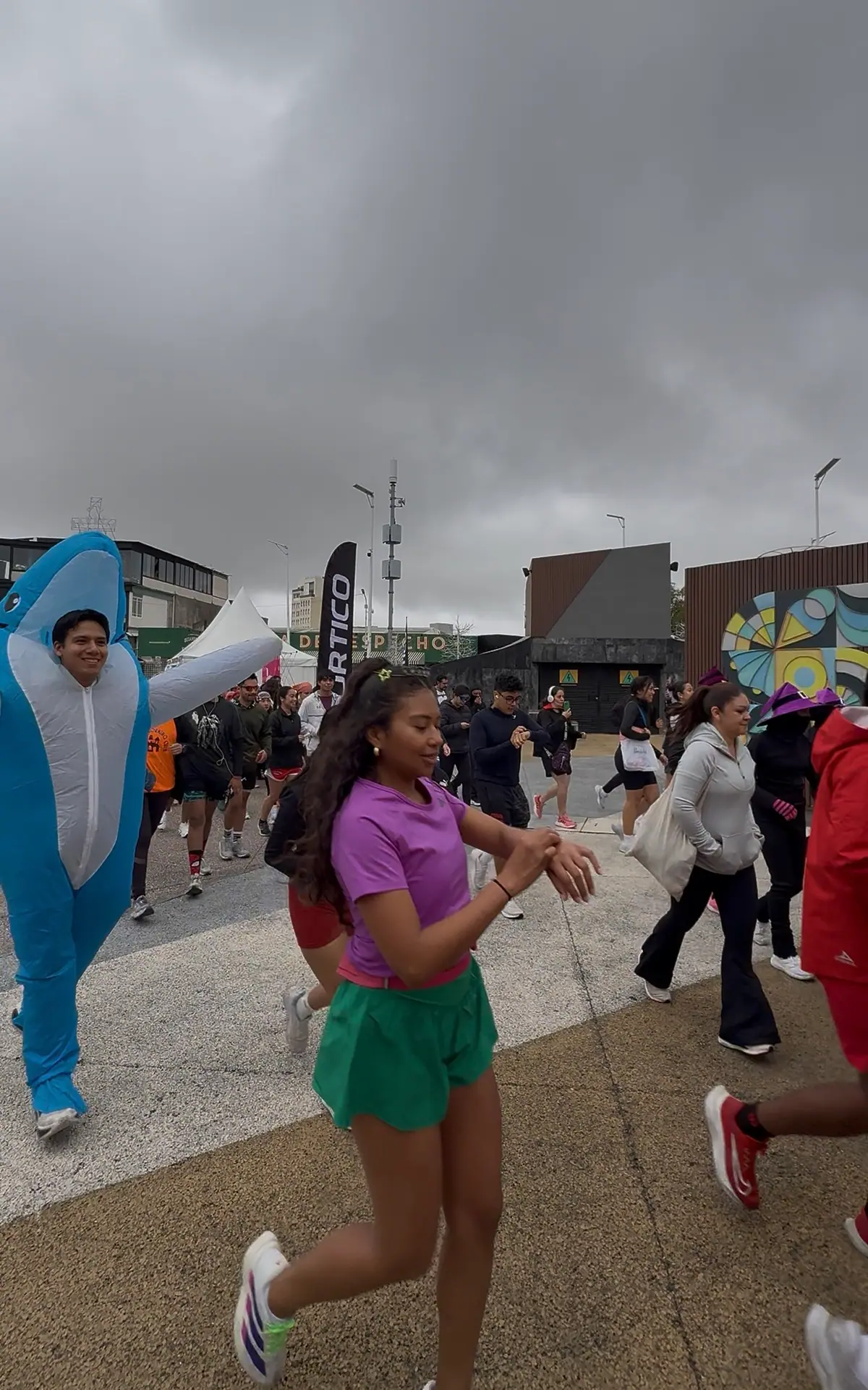 Un corredor con disfraz inflable de tiburón y una corredora durante el recorrido