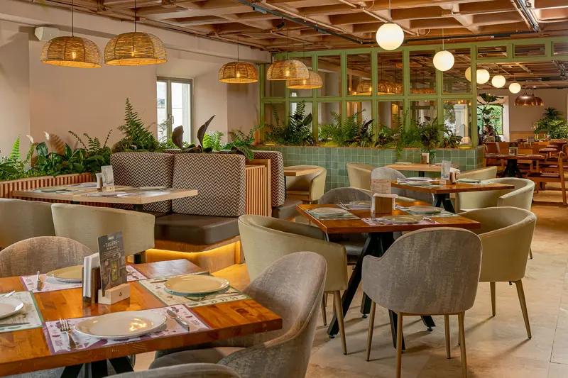 Salón de Tagers San Ángel con techo artesonado, lámparas tejidas y jardineras