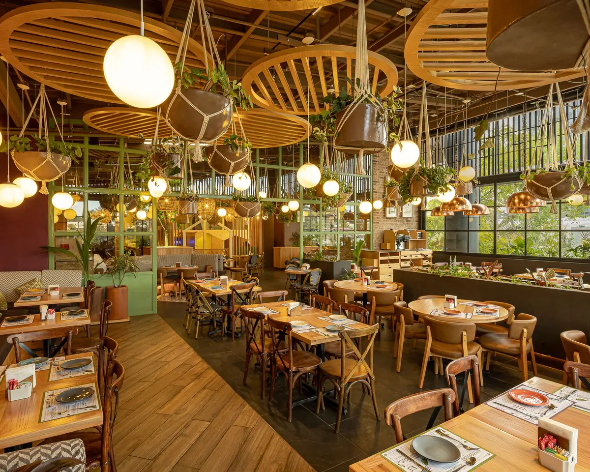 Salón de Tagers Zavaleta con lámparas de globo, celosías de madera y plantas colgantes, restaurante en Puebla
